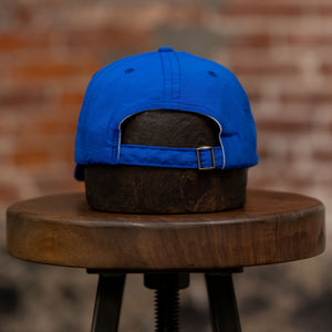 Franklin & Poe Surf Cap - Nylon Royal Blue on stool, facing away from the camera. Showing adjustable strap. 