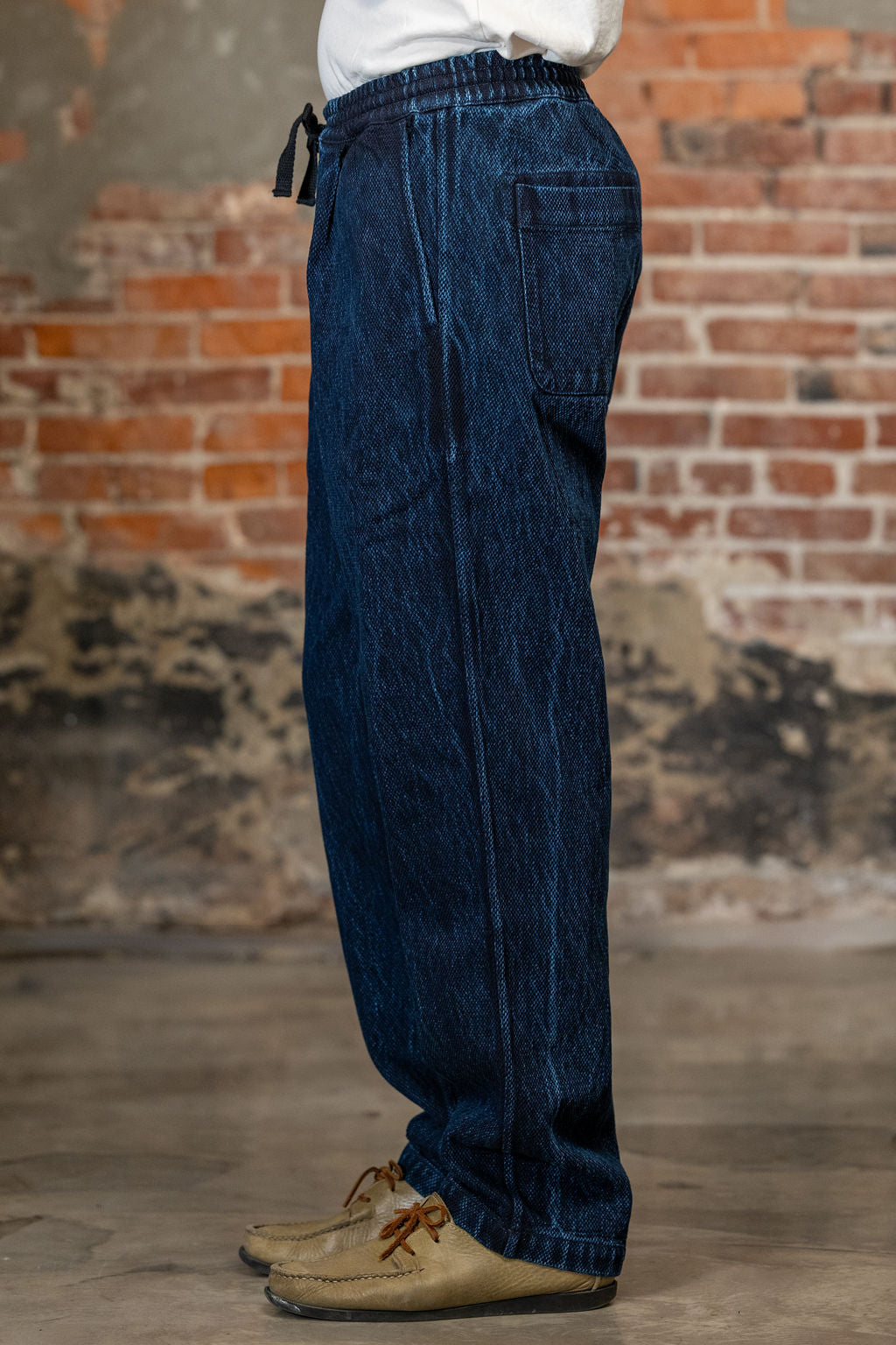 A person shown from the waist down wearing the 3sixteen Easy Pant - Indigo Kendo Cloth with side pockets 