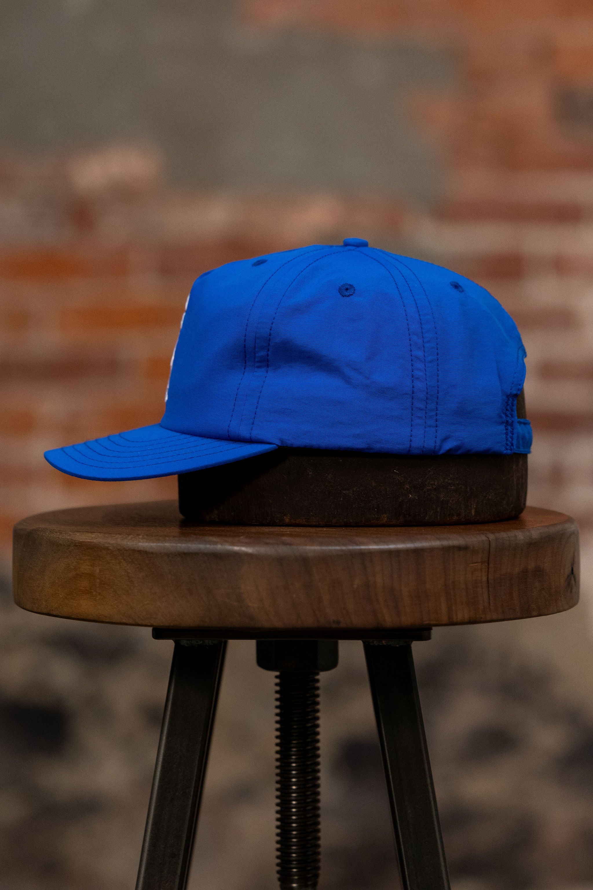 Franklin & Poe Surf Cap - Nylon Royal Blue on stool, facing the side