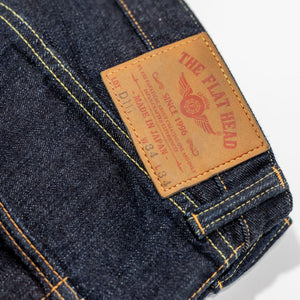 Indigo denim jeans wide cut back view laying flat close up on leather patch