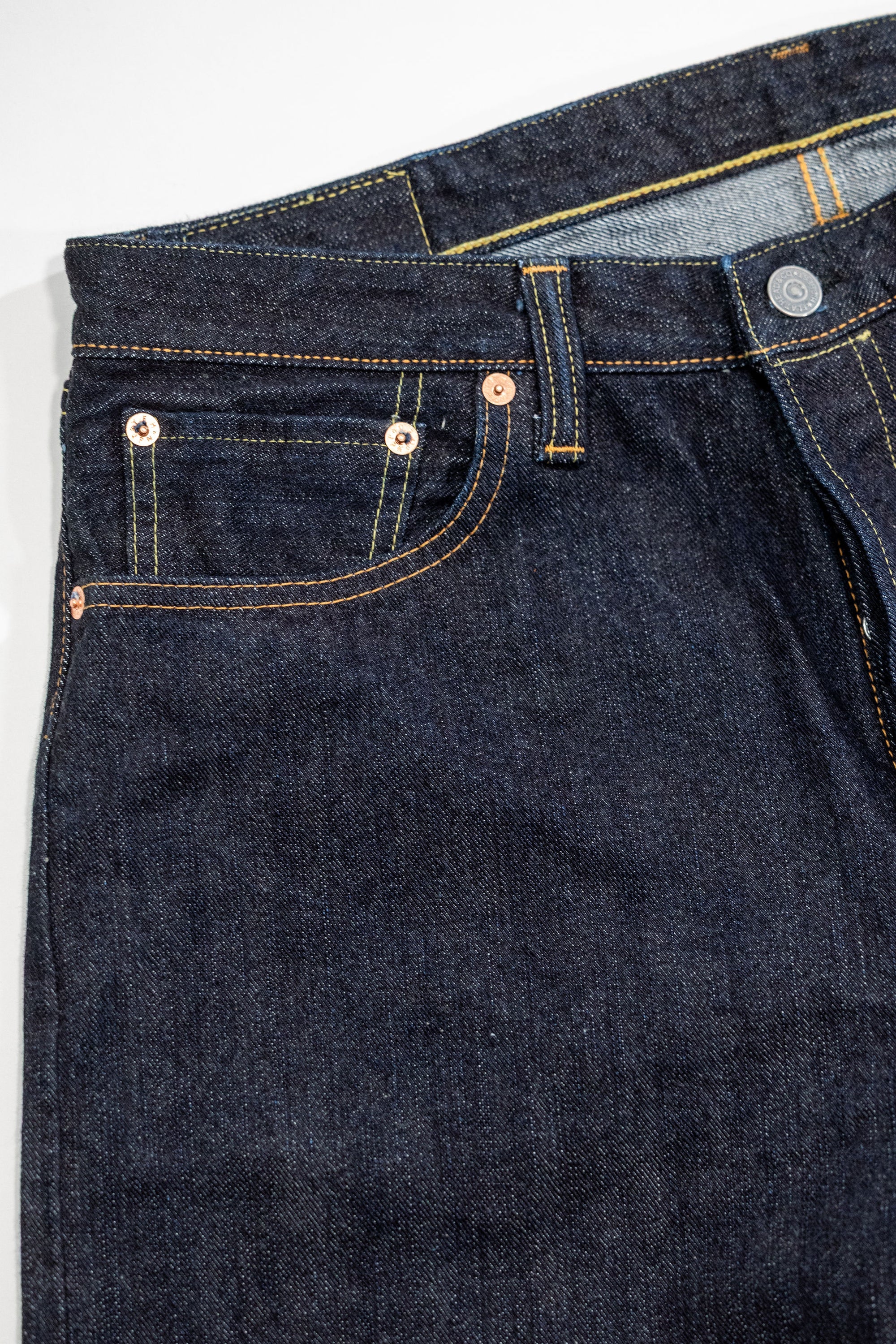 Indigo denim jeans wide cut front view laying flat close up