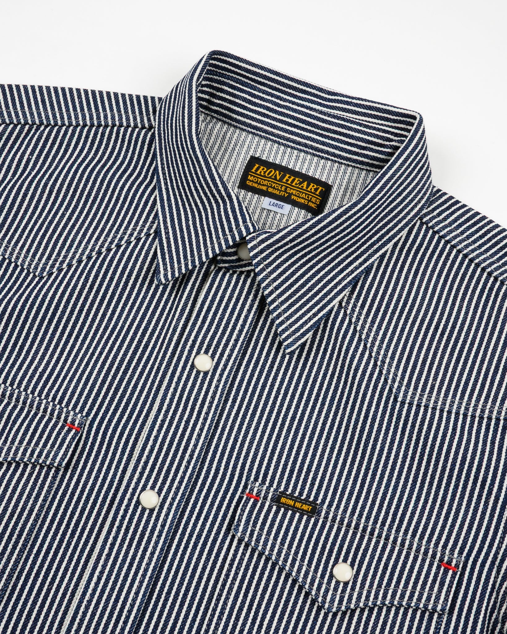 Western style shirt with indigo and white thin vertical stripes and white snaps front view close-up laying flat