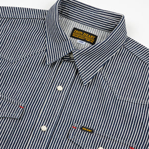 Western style shirt with indigo and white thin vertical stripes and white snaps front view close-up laying flat