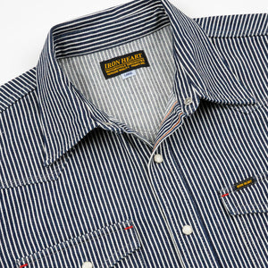Western style shirt with indigo and white thin vertical stripes and white snaps front view close-up second angle laying flat