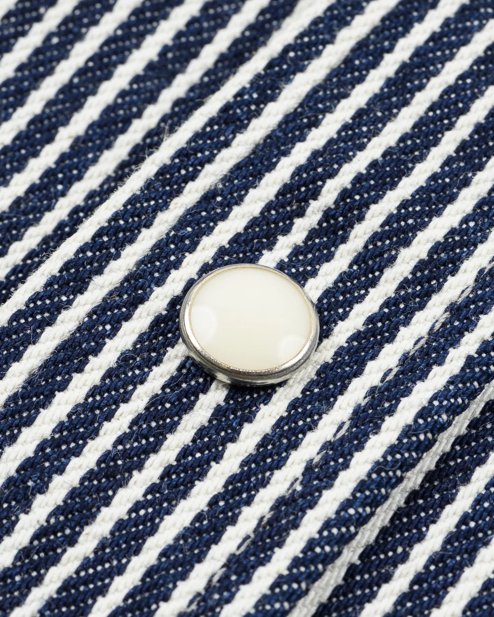 Western style shirt with indigo and white thin vertical stripes close-up on one white snap