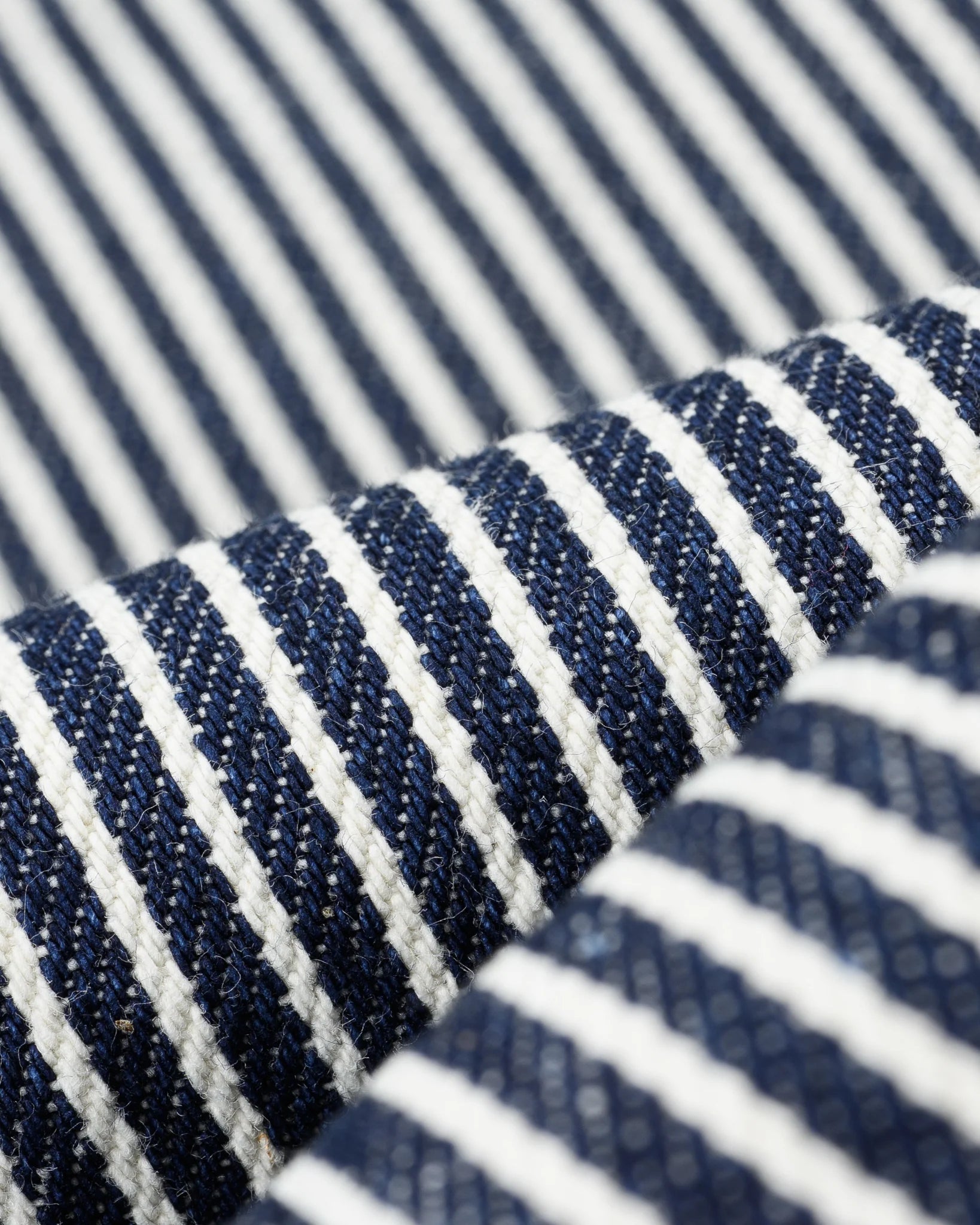 Western style shirt with indigo and white thin vertical stripes close-up on fabric
