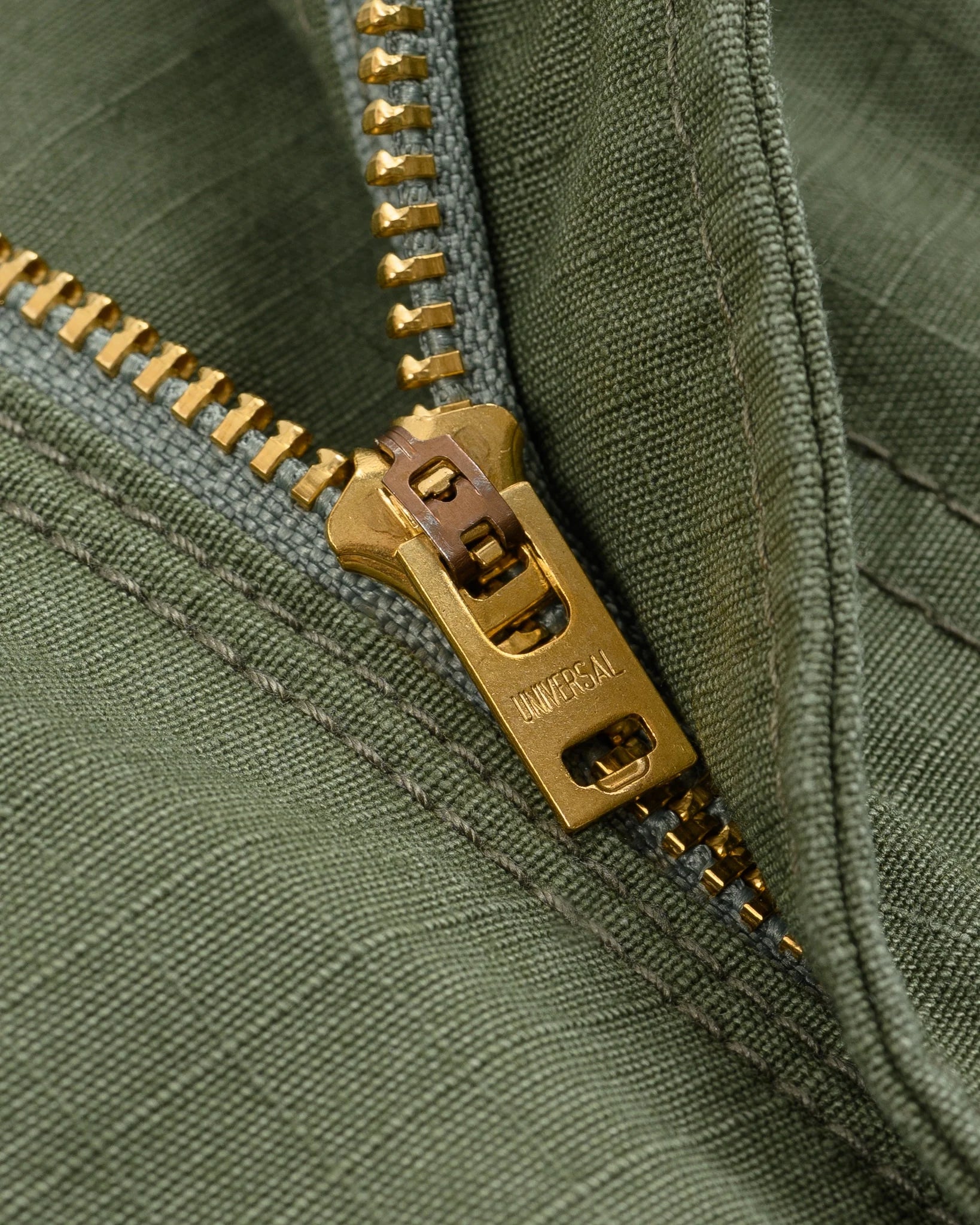 Olive pants laying flat closeup on zipper