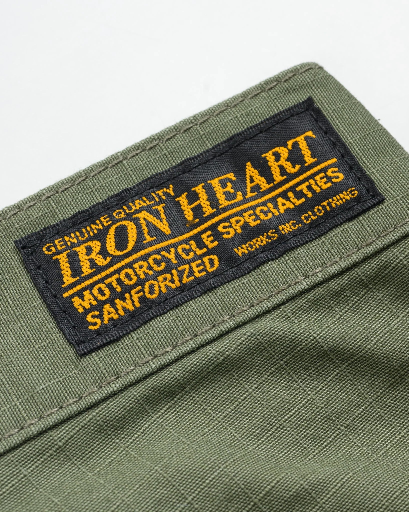 Olive pants laying flat closeup on Black/Yellow Iron Heart logo