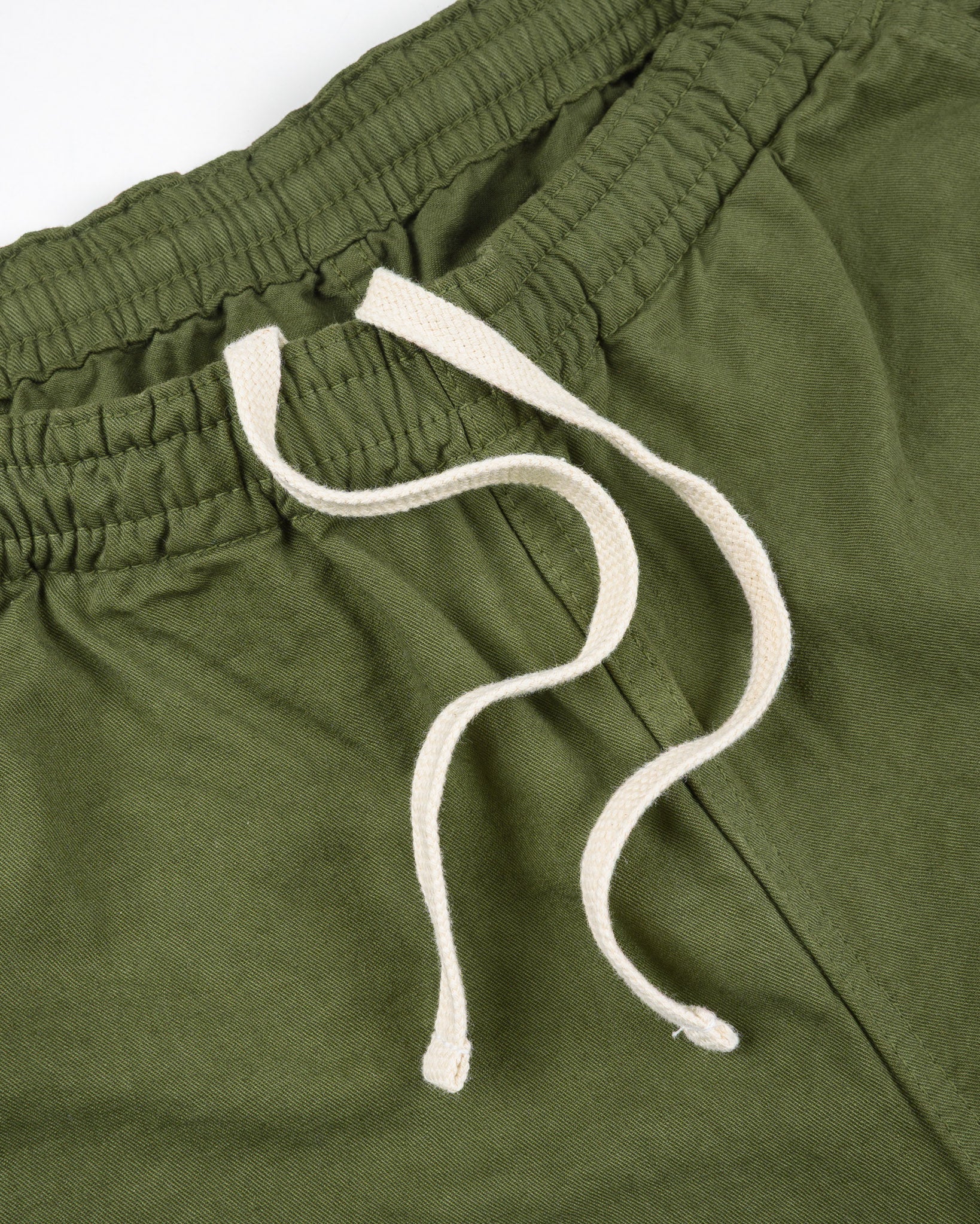 Olive mid length shorts laying flat closeup on white drawstring