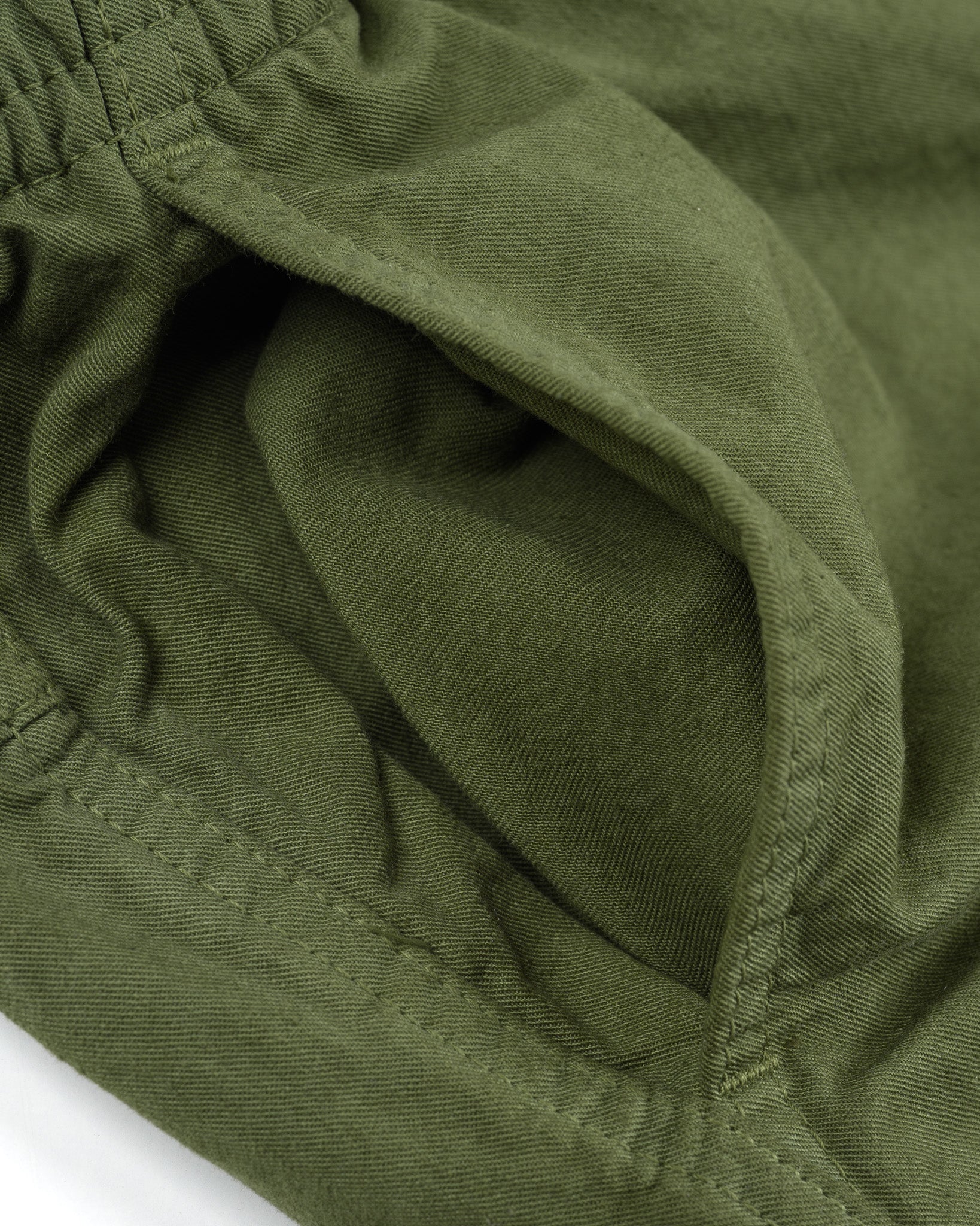 Olive mid length shorts laying flat closeup on side pocket