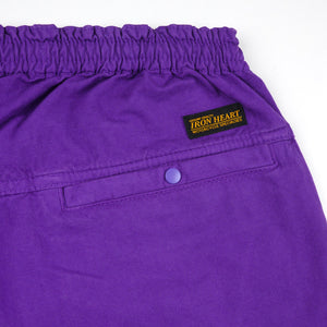 Purple mid length shorts back view laying flat closeup on snap pocket and black/yellow Iron Heart logo