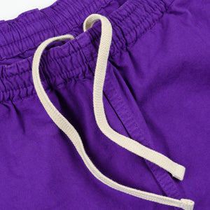 Purple mid length shorts laying flat closeup on white drawstring