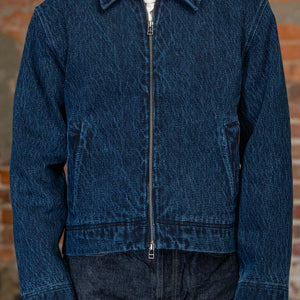 Front view of  person wearing 
the 3sixteen Club Jacket - Indigo Kendo Cloth, standing against a rustic brick wall.