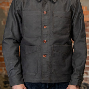 A man viewed from the front wearing
3sixteen French Work Jacket - Grey Moleskin, a dark charcoal gray long-sleeve button-up shirt 