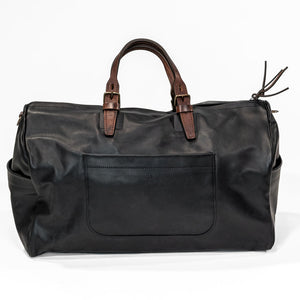 Black leather duffel bag with pockets and brown leather handles front view