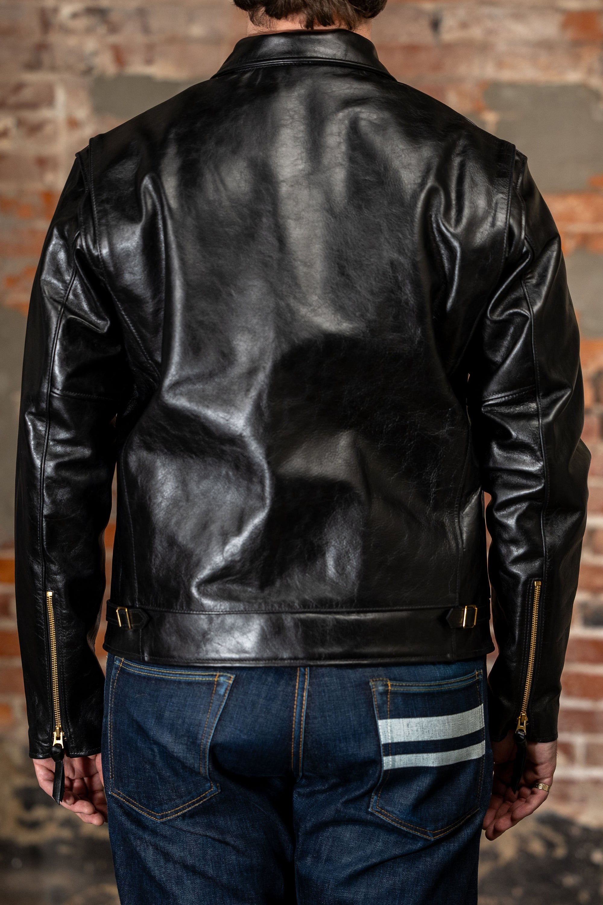 Model wearing back leather jacket from the back.