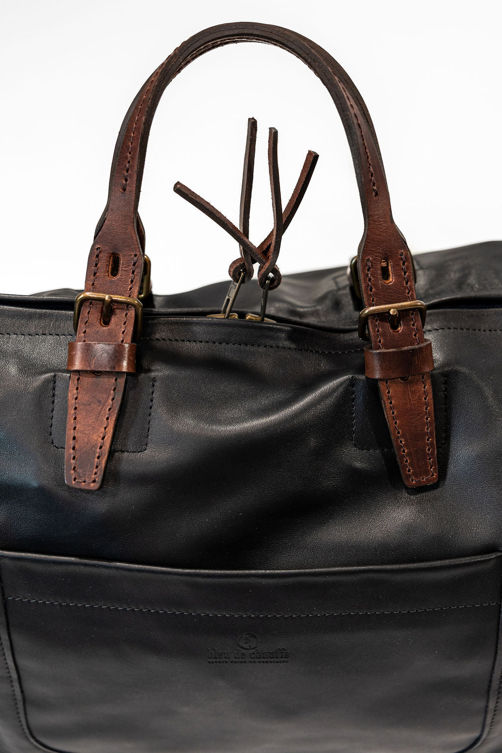 Black duffel bag with brown handles closeup on side