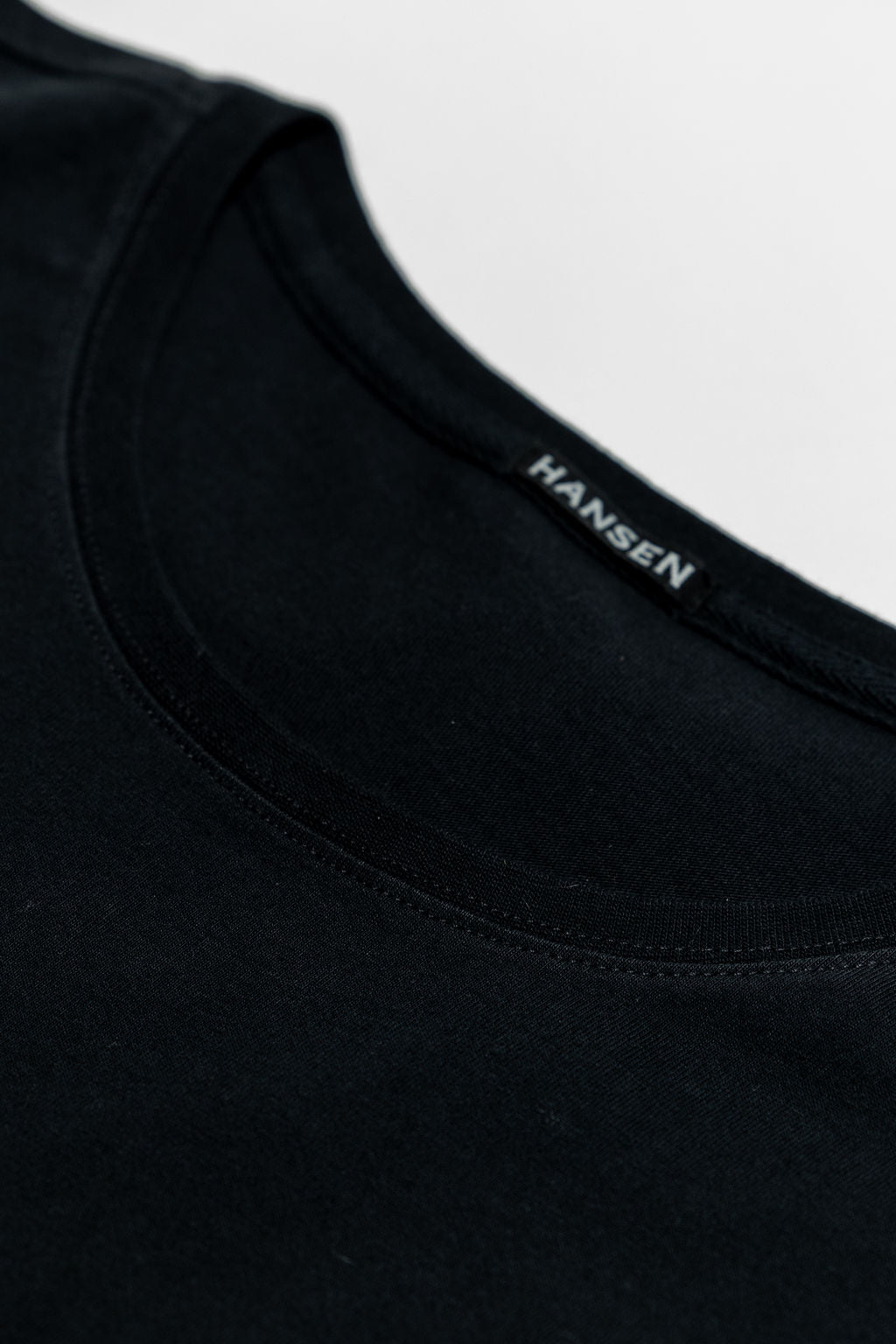 Hansen Garments Julian Crew Neck T-Shirt - Black laid flat. Details on neck stitching. 