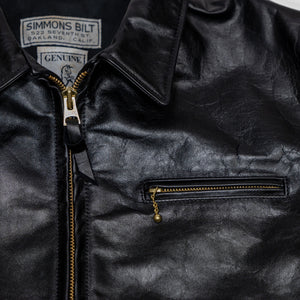 Black leather jacket laid flat on white. details of chest zipper & collar. 