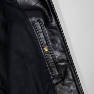 Black leather jacket laid flat on white. Internal chest pocket. 