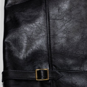 Black leather jacket laid flat on white. Details of side cinch.  