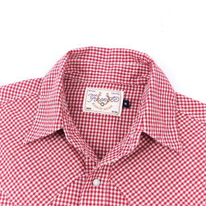 Red and white gingham western-style button-down shirt close up on collar laying flat