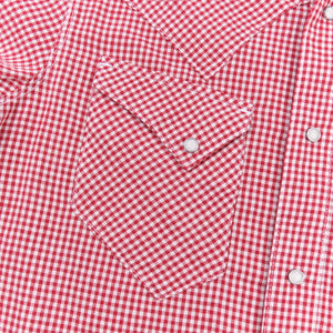 Red and white gingham western-style button-down shirt close up on right chest pocket laying flat