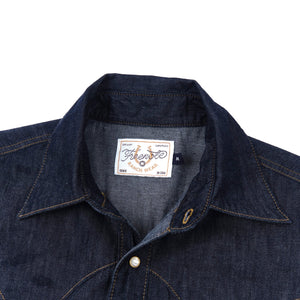 Dark indigo denim western-style shirt with white snaps, close up on collar laying flat
