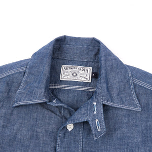 Shirt laid flat on white, from the front. Close up on collar.
