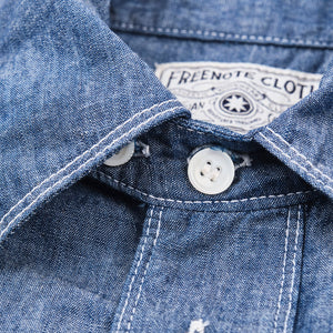Shirt laid flat, from the front. Close up on collar buttons
