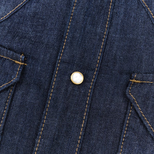 Dark indigo denim western-style short sleeve shirt with white snaps, close up on snap laying flat